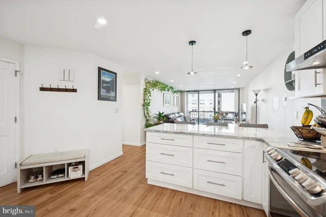 a kitchen with kitchen island a stove a sink a center island and wooden floor