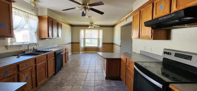 a kitchen with stainless steel appliances a sink stove and cabinets
