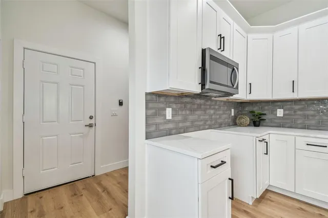 a kitchen with white cabinets sink and stove