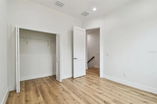 an empty room with wooden floor and entrance