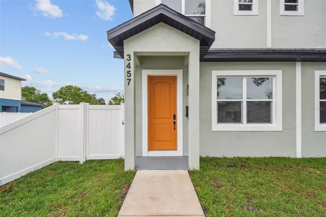 a view of a house with a small yard and wooden floor and fence