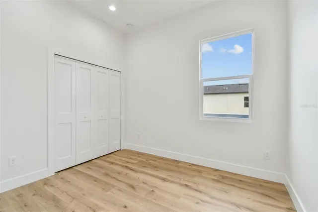 an empty room with wooden floor and closet