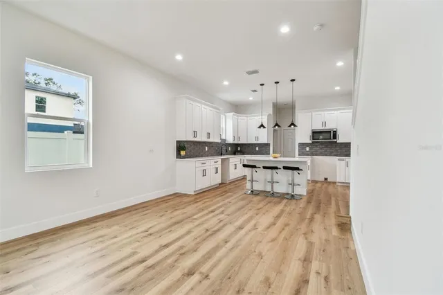 a kitchen with stainless steel appliances kitchen island granite countertop a refrigerator and cabinets