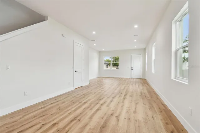 a view of empty room with wooden floor