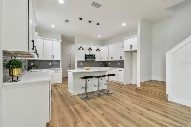 a kitchen with kitchen island a stove a sink a refrigerator and a wooden cabinets
