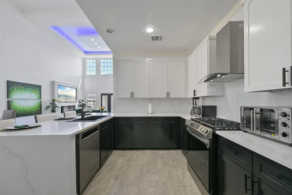 a kitchen with granite countertop a sink dishwasher stove and cabinets