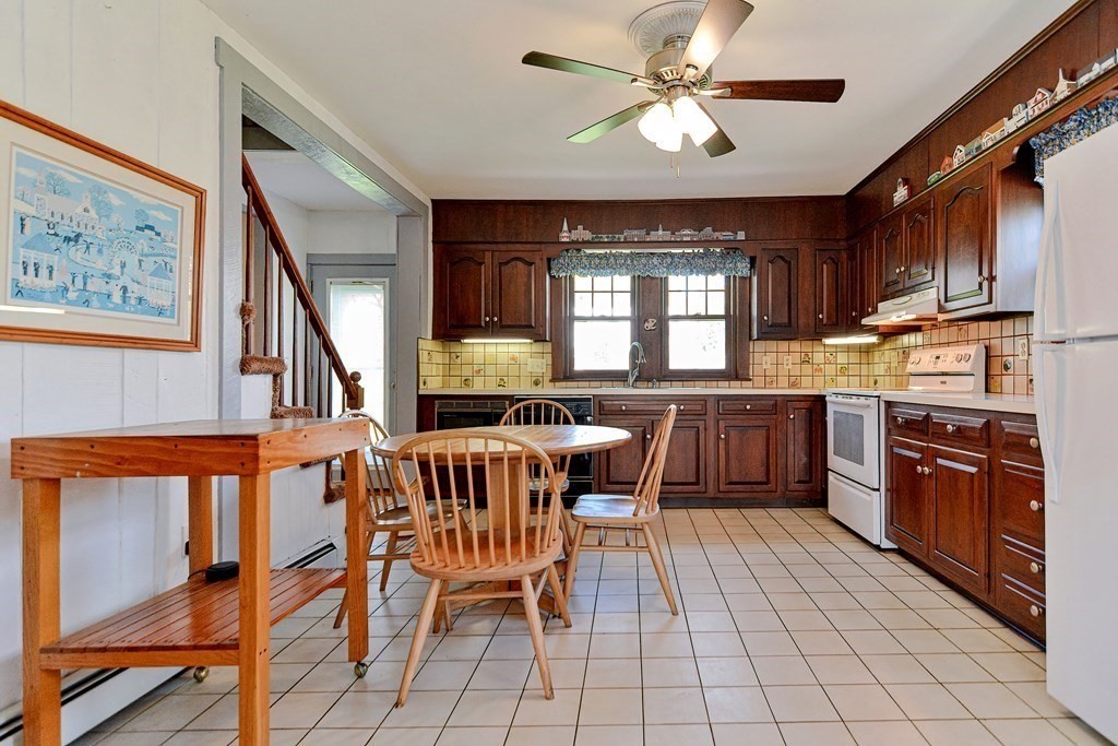18 1/2 Whitney Street Milford, MA 01757 - Photo 15 of 34 a kitchen with stainless steel appliances granite countertop a stove top oven a sink a dining table and chairs with wooden floor