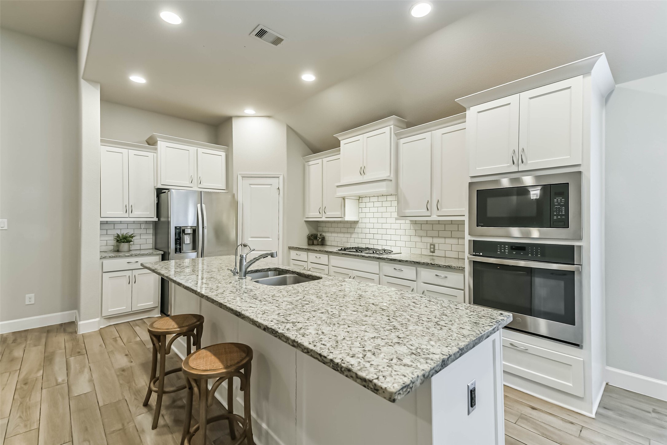 8132 Tyrell Hgts Road Magnolia, TX 77354 - Photo 10 of 40 Kitchen features corner walk-in pantry and generous island with built-in seating space, perfect for entertaining and everyday living.