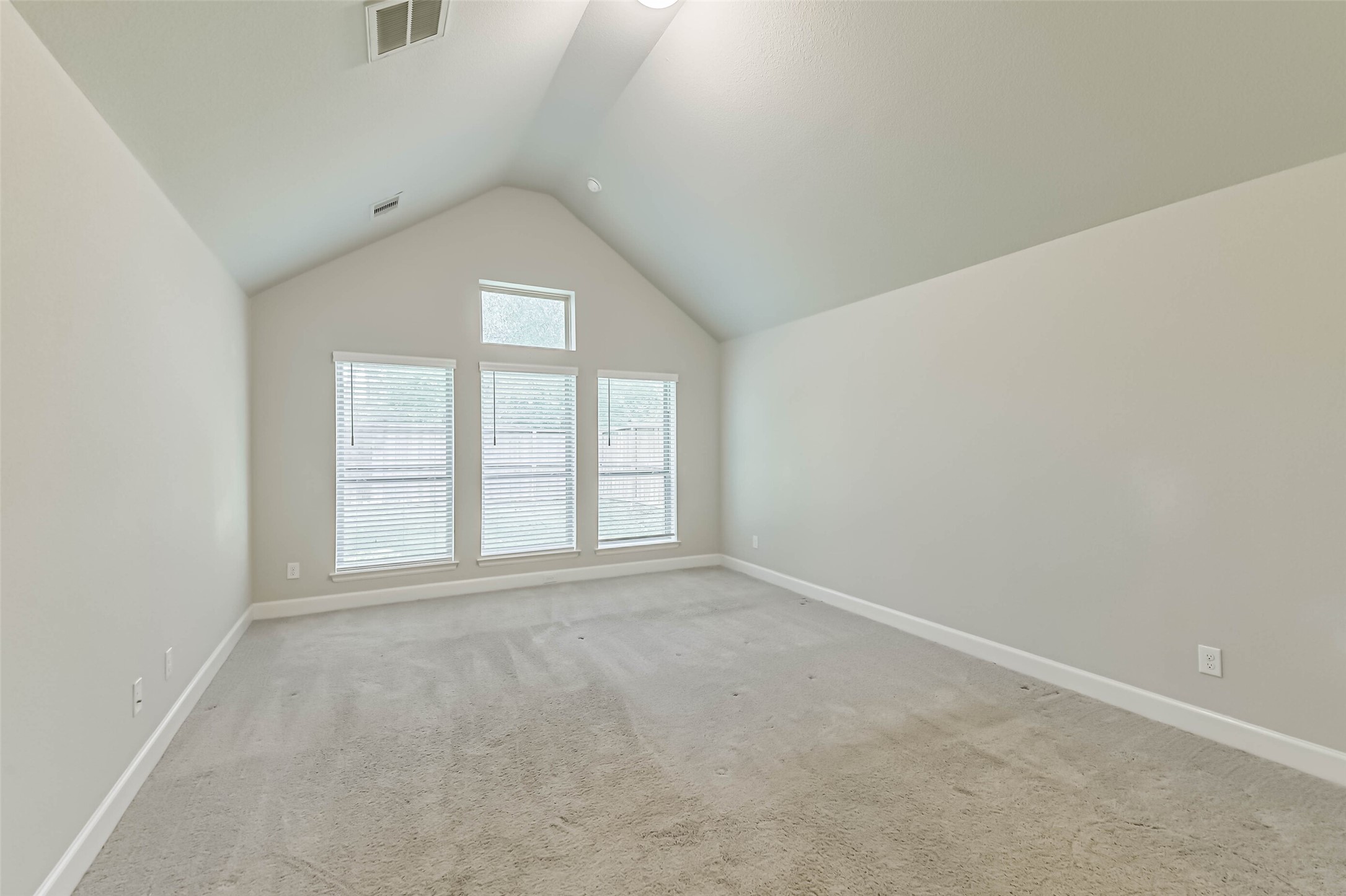 8132 Tyrell Hgts Road Magnolia, TX 77354 - Photo 15 of 40 Experience luxury and natural light in this primary bedroom, featuring soaring 12-foot ceilings and an expansive wall of windows.