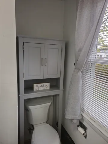a view of a livingroom with a fireplace and window