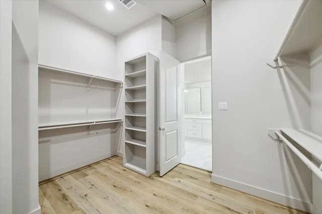 a view of walk in closet with empty racks