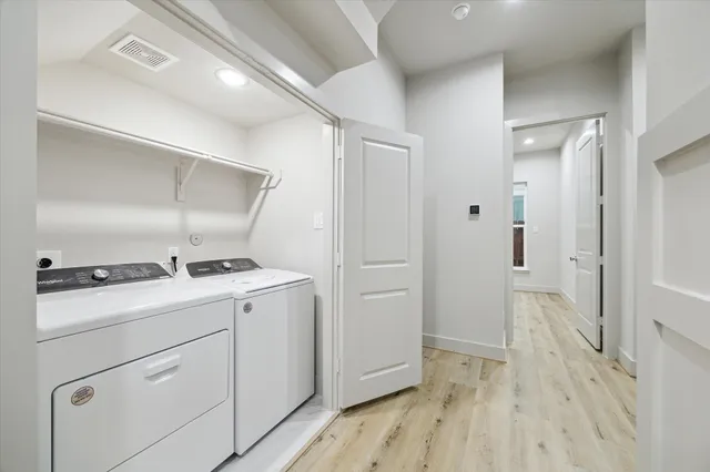 a view of a kitchen with a stove wooden floor and a hallway
