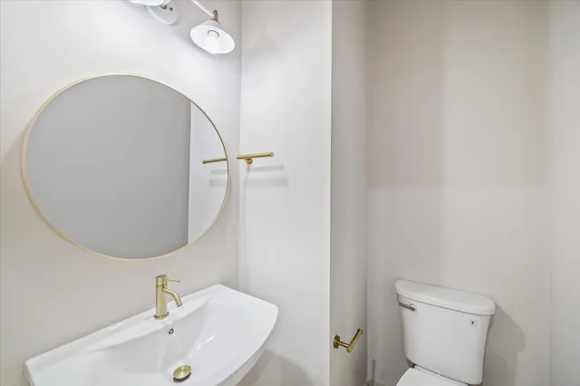 a bathroom with a sink and mirror with toilet