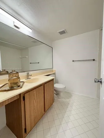 a bathroom with a sink a toilet and mirror