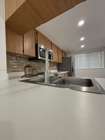 a kitchen with stainless steel appliances granite countertop a sink and a stove