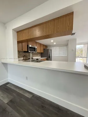 a kitchen with a sink cabinets and wooden floor