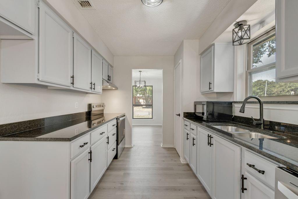 3510 Jonquil Lane Rowlett, TX 75089 - Photo 13 of 35 a kitchen with granite countertop a sink and cabinets