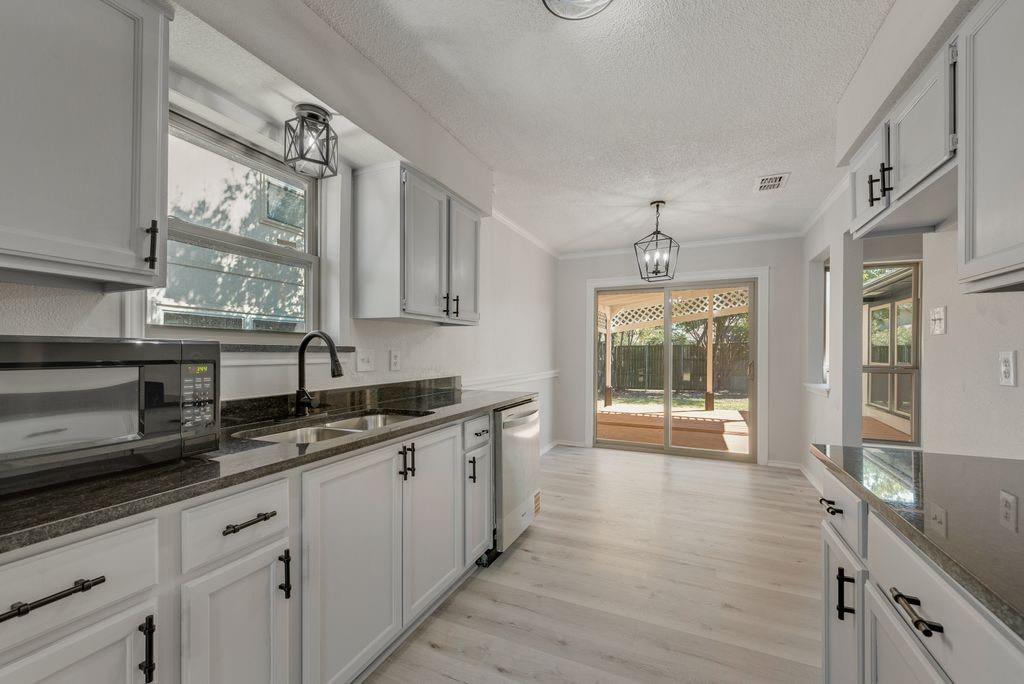 3510 Jonquil Lane Rowlett, TX 75089 - Photo 14 of 35 a kitchen with granite countertop a sink a counter space appliances and cabinets