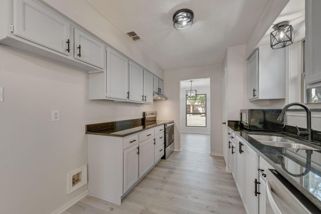 3510 Jonquil Lane Rowlett, TX 75089 - Photo 15 of 35 a kitchen with granite countertop a sink stove and cabinets