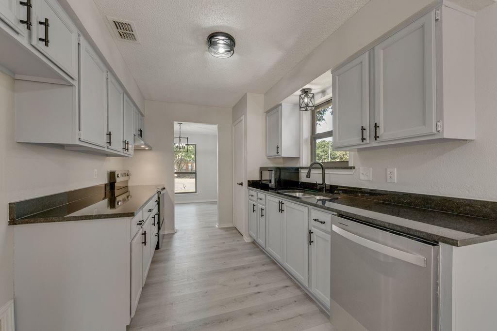 3510 Jonquil Lane Rowlett, TX 75089 - Photo 16 of 35 a kitchen with stainless steel appliances granite countertop a sink stove and cabinets
