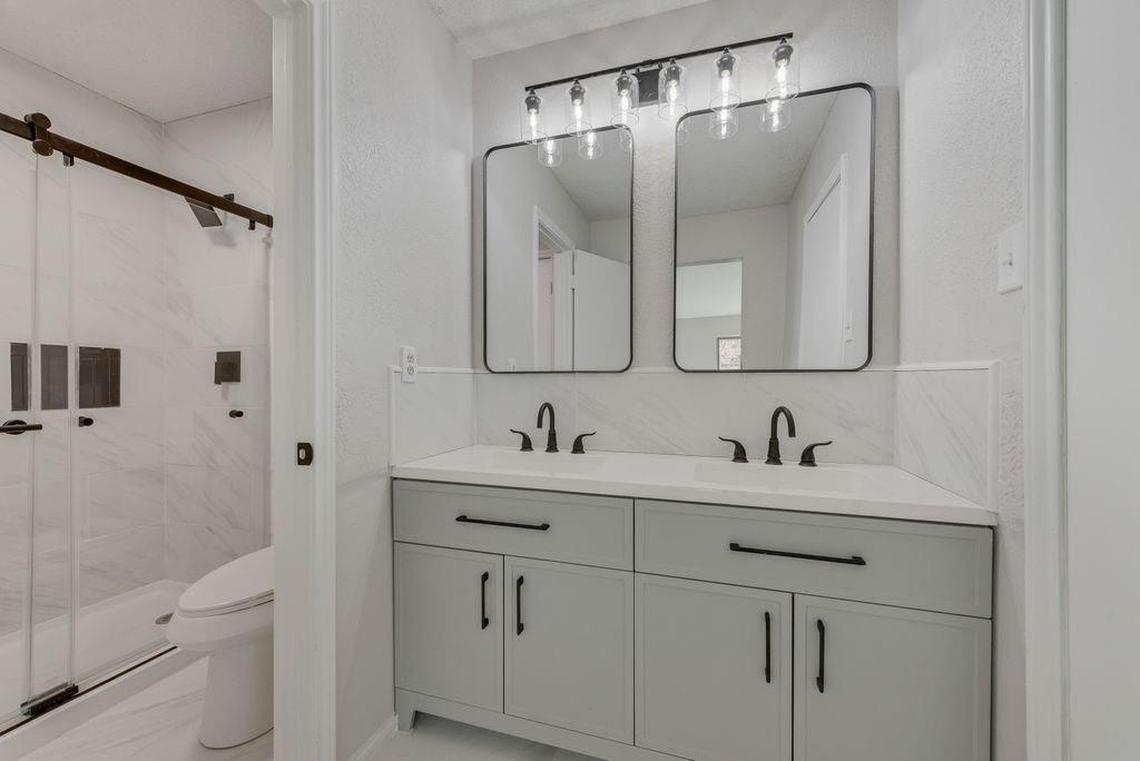 3510 Jonquil Lane Rowlett, TX 75089 - Photo 24 of 35 a bathroom with a sink vanity toilet and shower