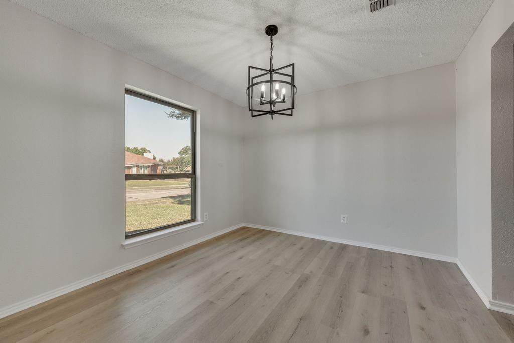 3510 Jonquil Lane Rowlett, TX 75089 - Photo 7 of 35 a view of an empty room with a window and wooden floor
