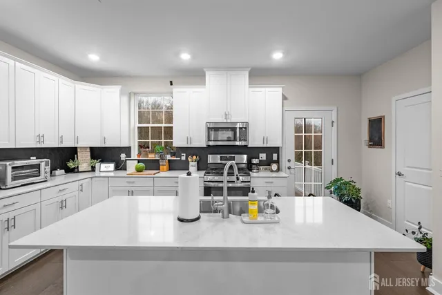 a view of kitchen with stainless steel appliances granite countertop dining room and wooden floor