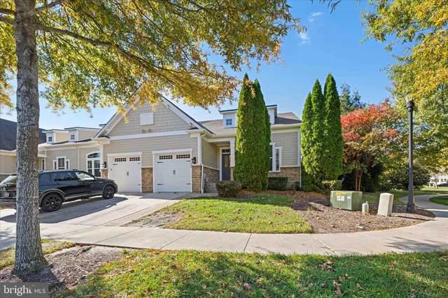 a front view of a house with a yard and trees