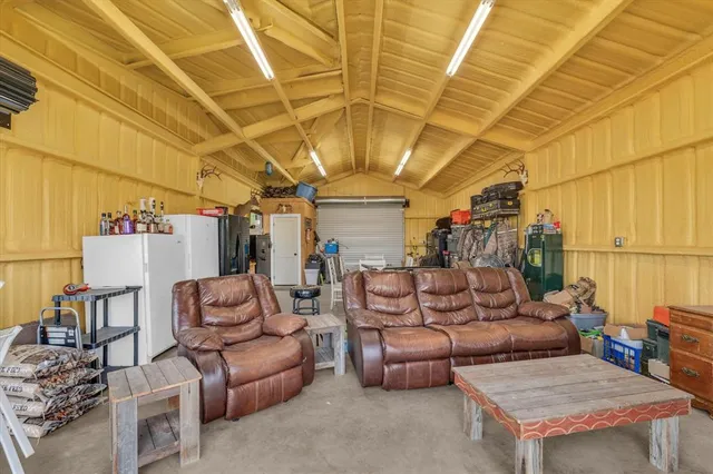 a living room with furniture a flat screen tv and a floor to ceiling window