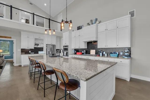 a kitchen with granite countertop a sink appliances and cabinets