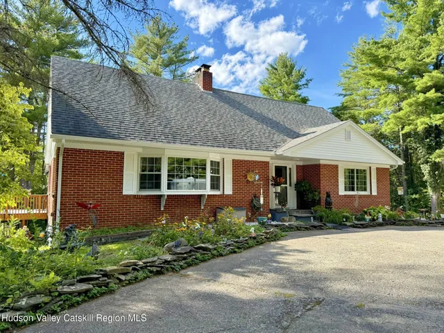 a front view of a house with a yard and potted plants