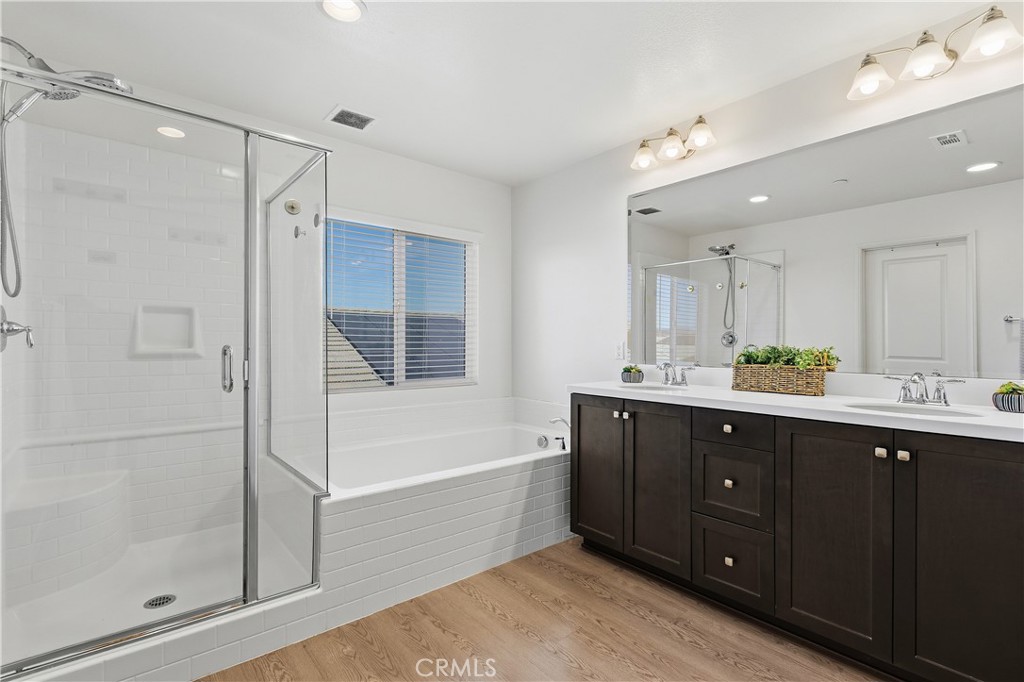 34727 Ribbon Grass Way Murrieta, CA 92563 - Photo 16 of 54 Spa-inspired primary bathroom with dual vanities, a separate soaking tub and walk-in shower, plus a private toilet room