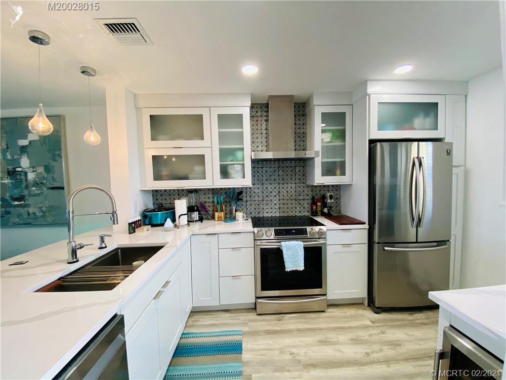 7440 South Ocean Drive, Unit 524A Jensen Beach, FL 34957 - Photo 19 of 64 a kitchen with a white cabinets and stainless steel appliances