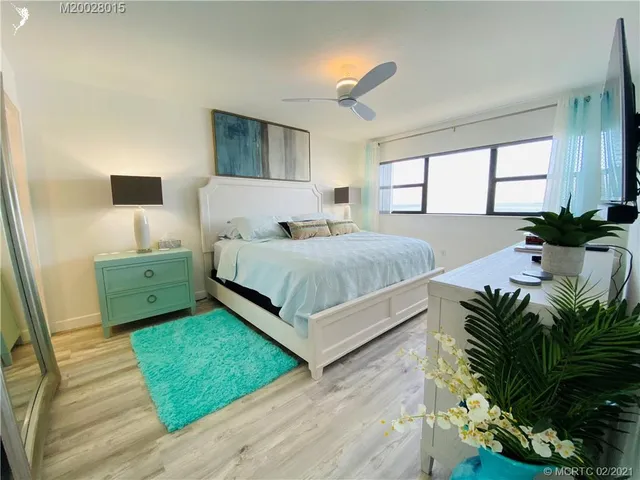 a bedroom with bed and flat tv screen on dresser