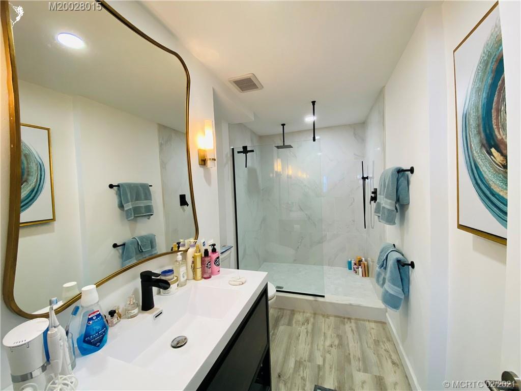 7440 South Ocean Drive, Unit 524A Jensen Beach, FL 34957 - Photo 46 of 64 a bathroom with a tub sink and mirror