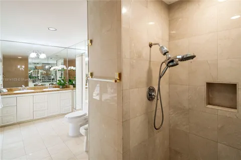 a bathroom with a granite countertop shower a sink and a mirror