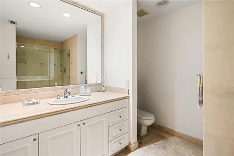 a bathroom with a granite countertop sink a toilet and a mirror