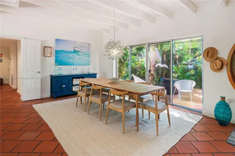 a dining room with furniture and a floor to ceiling window
