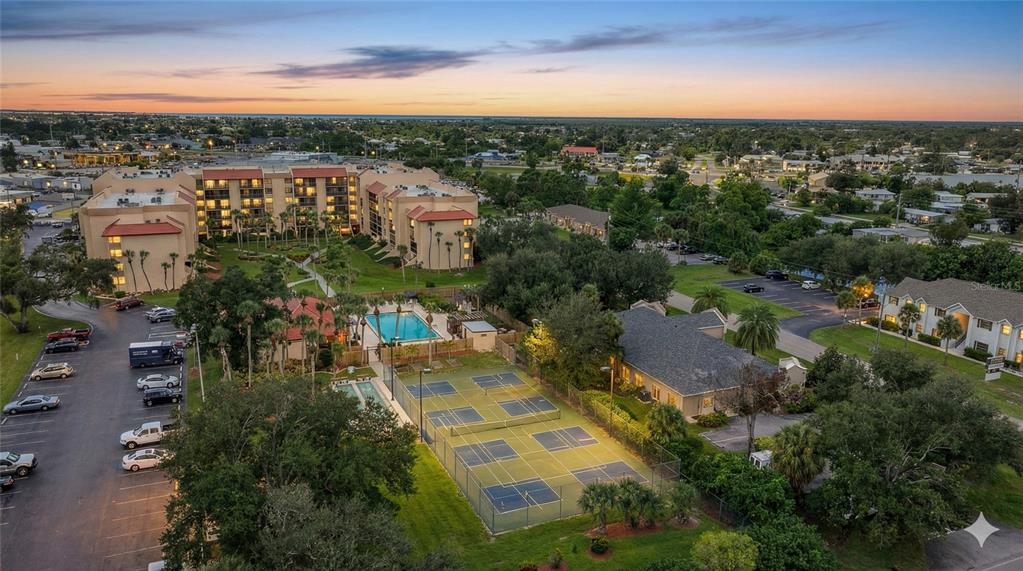3006 Caring Way, Unit 329 Port Charlotte, FL 33952 - Photo 26 of 37 an aerial view of a city with lots of residential buildings ocean and mountain view in back