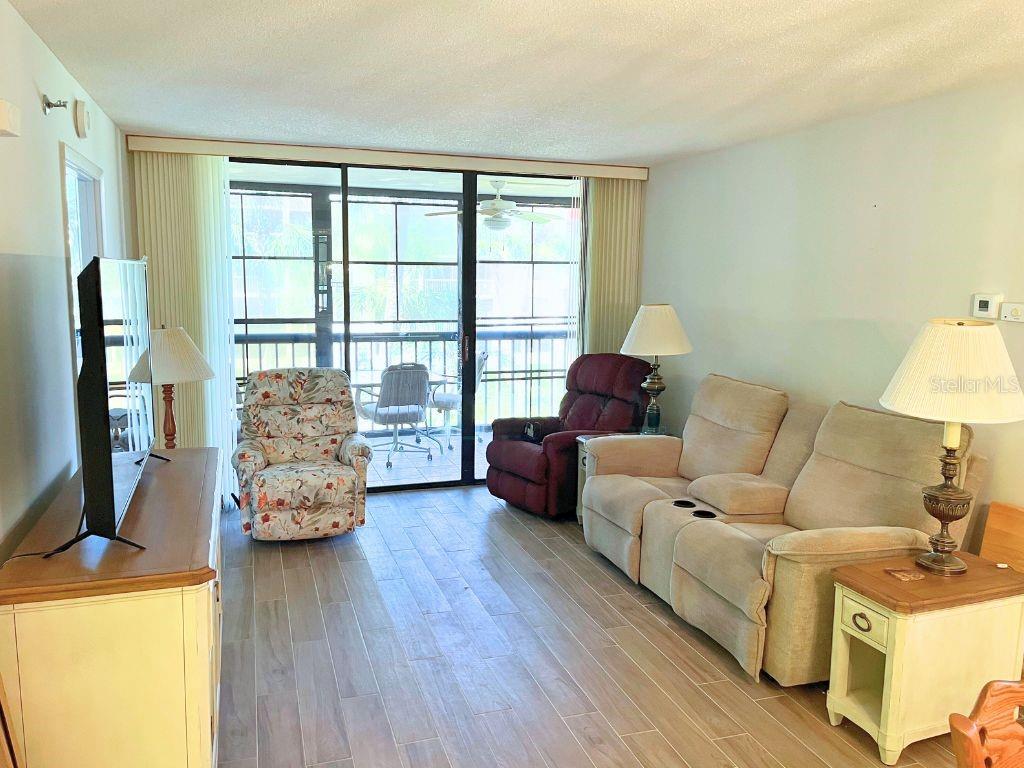 3006 Caring Way, Unit 329 Port Charlotte, FL 33952 - Photo 3 of 37 a living room with furniture and a flat screen tv