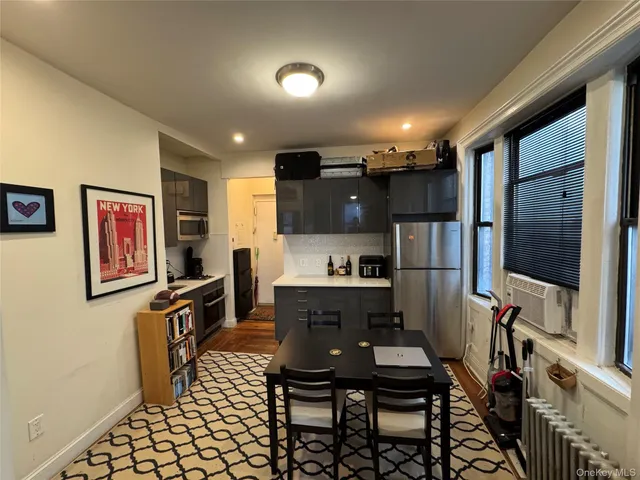 a kitchen with a dining table chairs and refrigerator