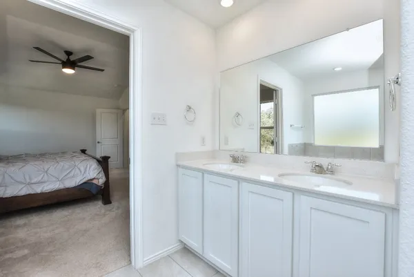 a en suite bathroom with a double vanity sink and mirror