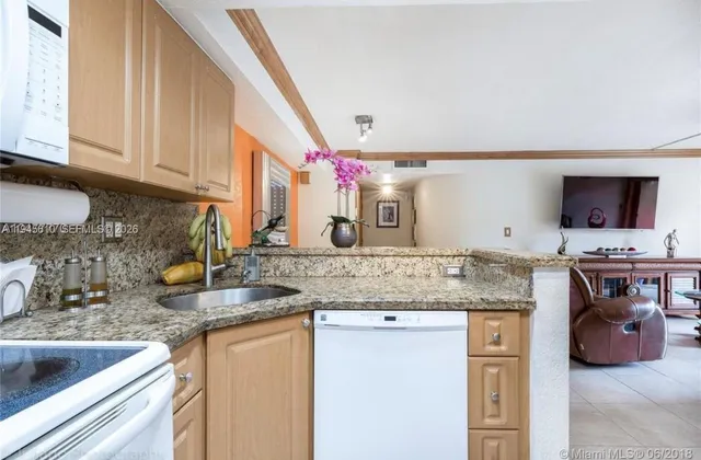 a kitchen with stainless steel appliances granite countertop a sink and a stove