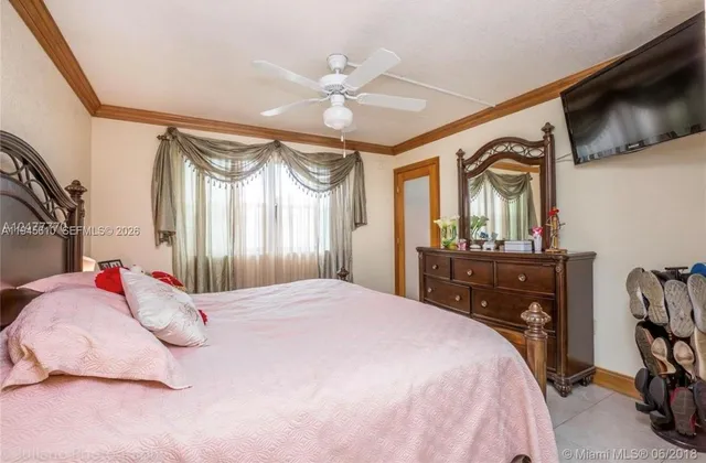 a bedroom with a bed dresser and a flat tv screen