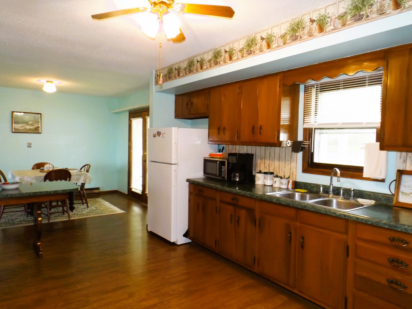 7573 Blue Goose Road Prophetstown, IL 61277 - Photo 11 of 24 a kitchen with kitchen island granite countertop a sink appliances cabinets and a large window