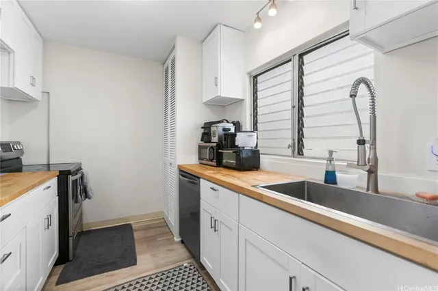 a kitchen with stainless steel appliances granite countertop a sink a stove and a refrigerator