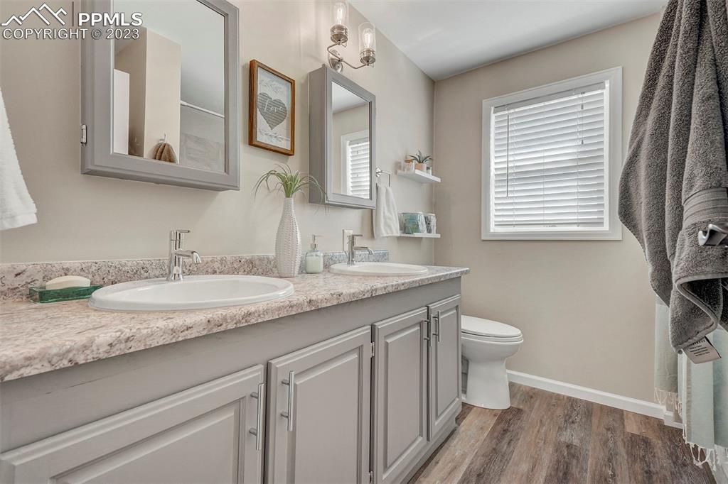 21750 Scott Road Calhan, CO 80808 - Photo 28 of 50 a bathroom with a granite countertop sink a toilet and a mirror