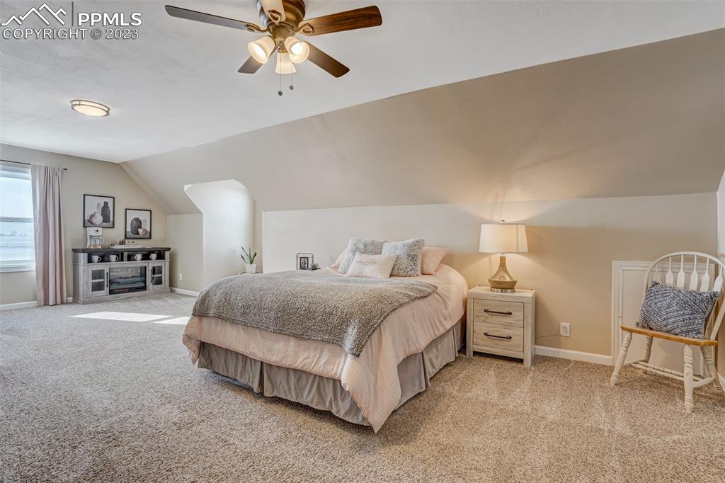 21750 Scott Road Calhan, CO 80808 - Photo 36 of 50 a spacious bedroom with a bed and a chandelier
