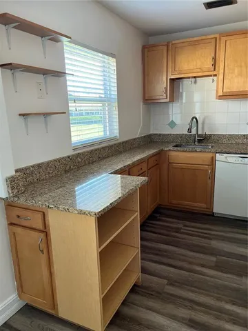 a kitchen with granite countertop cabinets appliances and a window