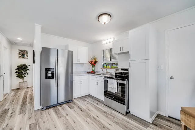 a kitchen with a refrigerator a stove top oven a sink and cabinets